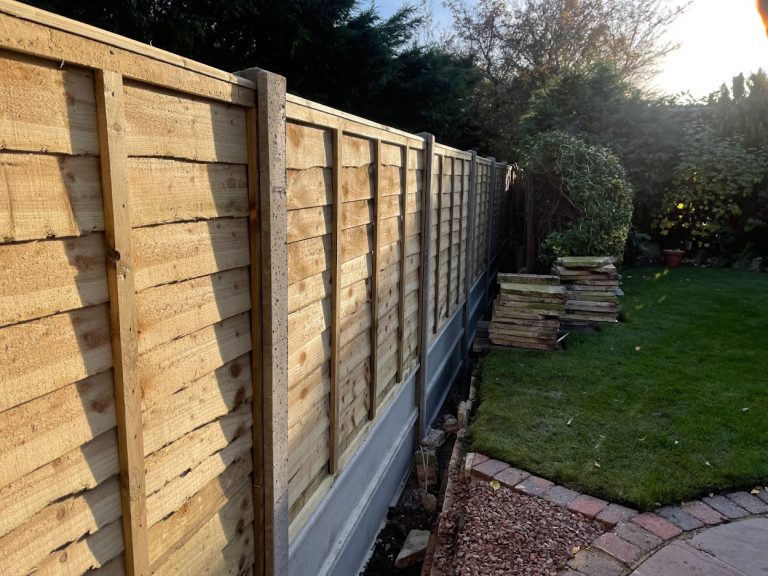 Waney Edge fence panels with concrete posts and twin gravel boards